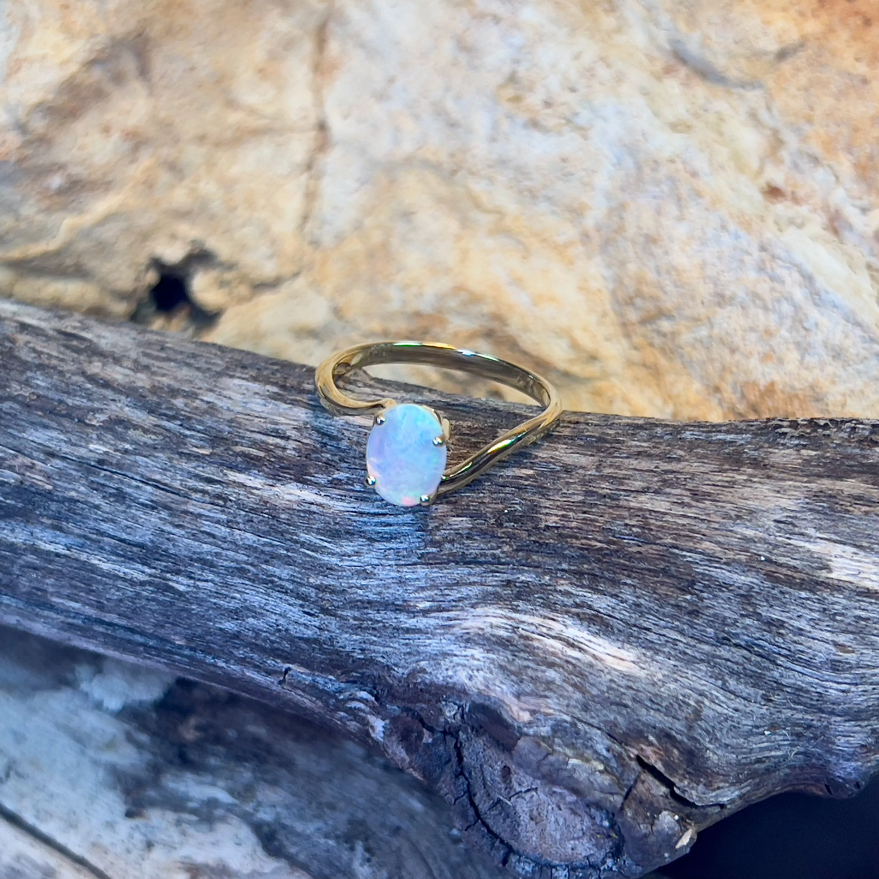 14kt Yellow Gold crossover ring with one 0.55ct Crystal Opal